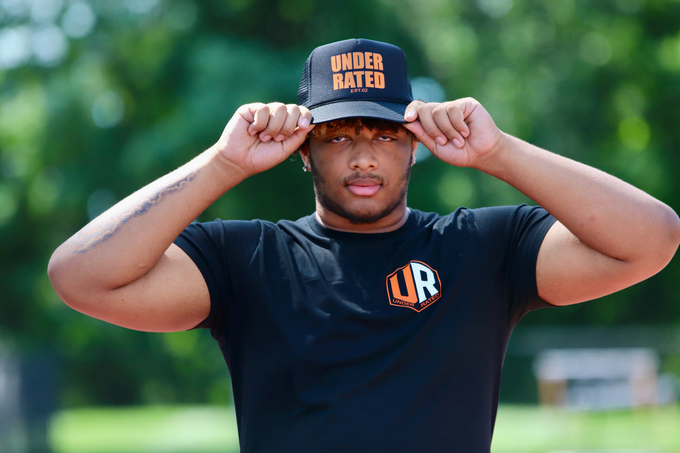 BLACK UNDERRATED TRUCKER HAT WITH ORANGE FONT
