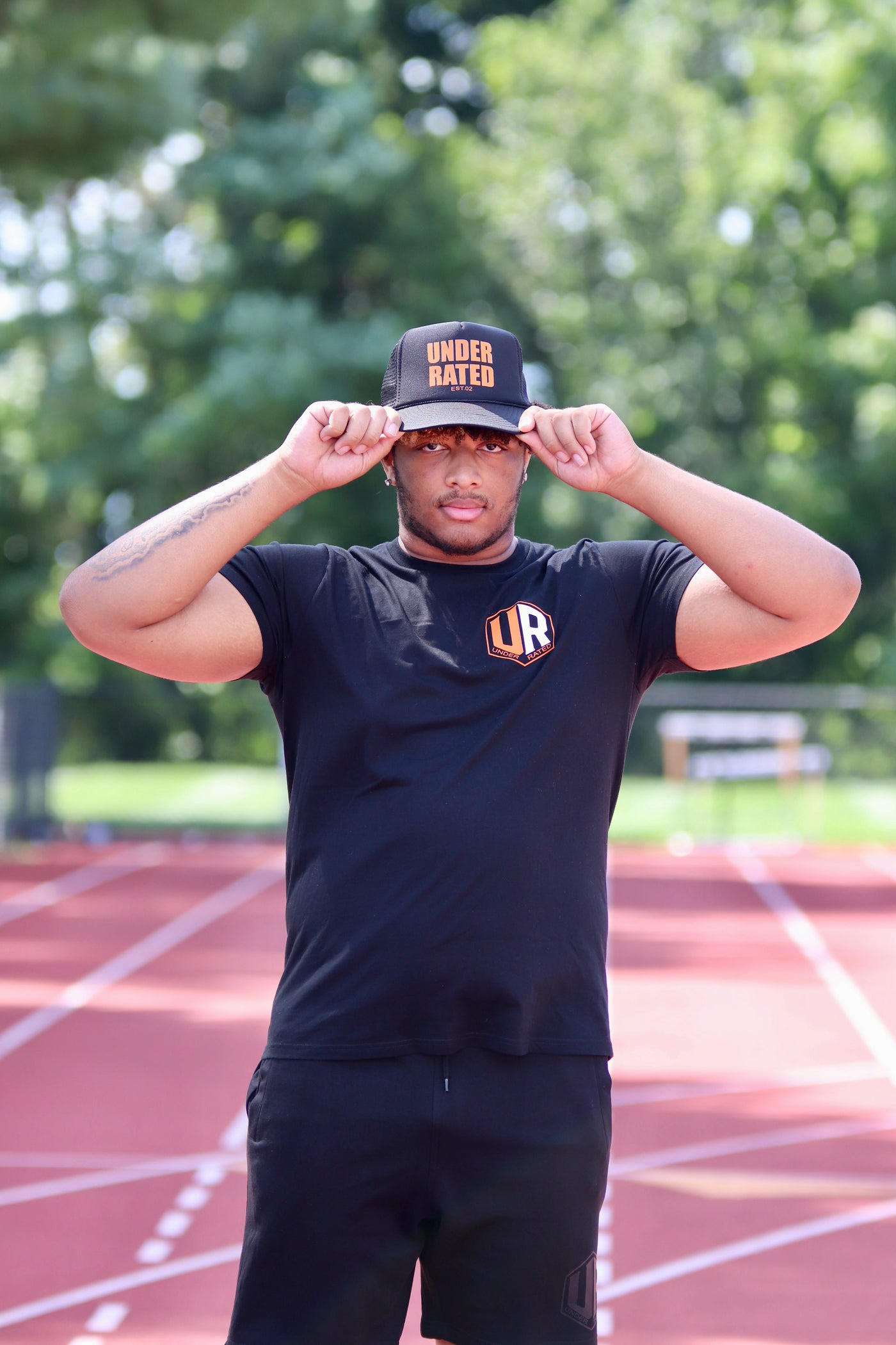 BLACK UNDERRATED TRUCKER HAT WITH ORANGE FONT