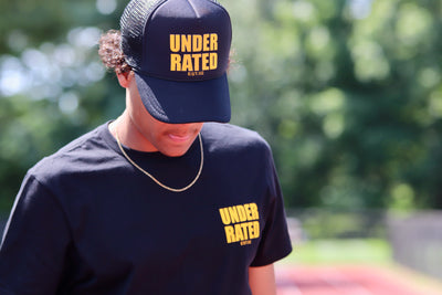 BLACK UNDERRATED TRUCKER HAT WITH YELLOW FONT